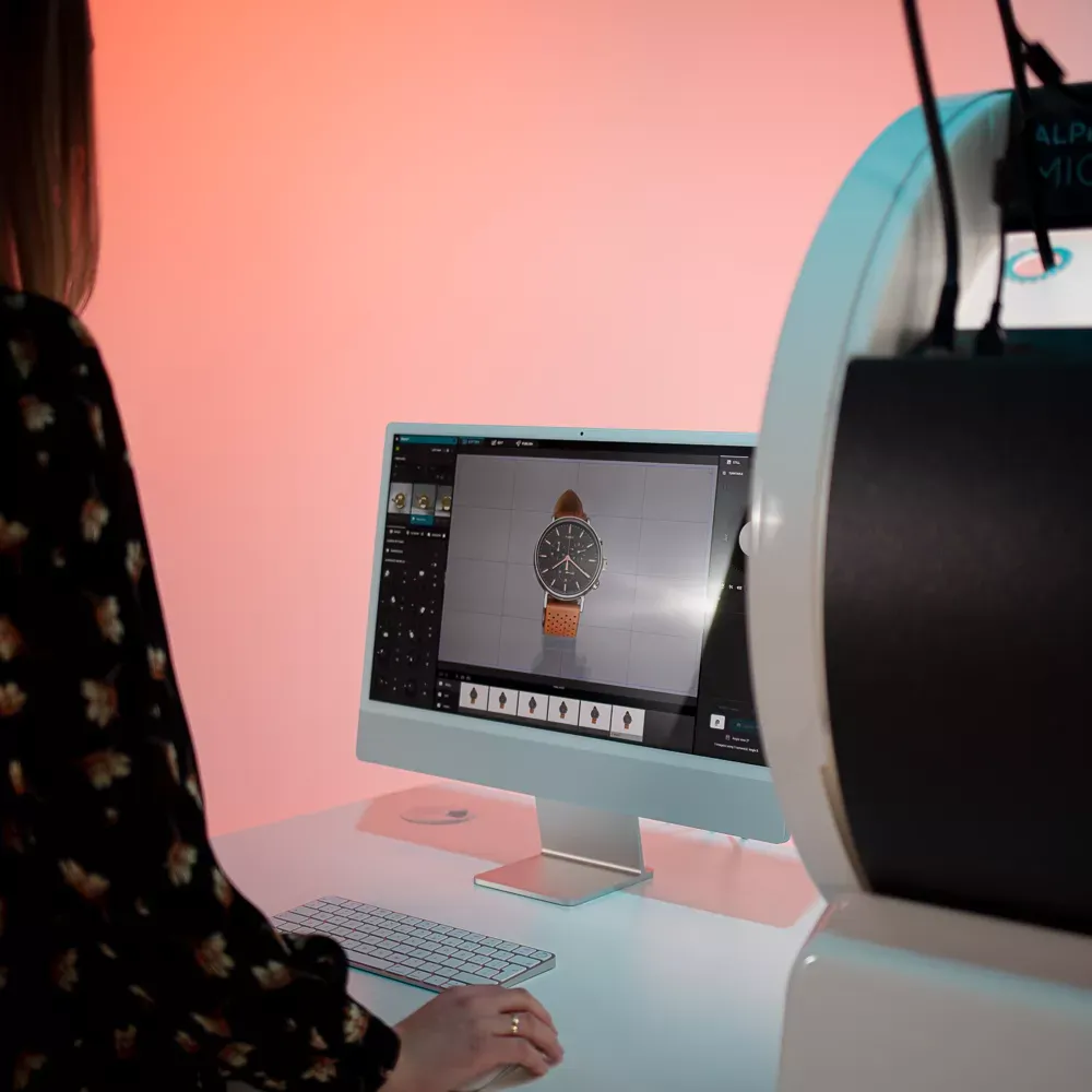 Femme photographiant une montre avec une interface logicielle sur ordinateur