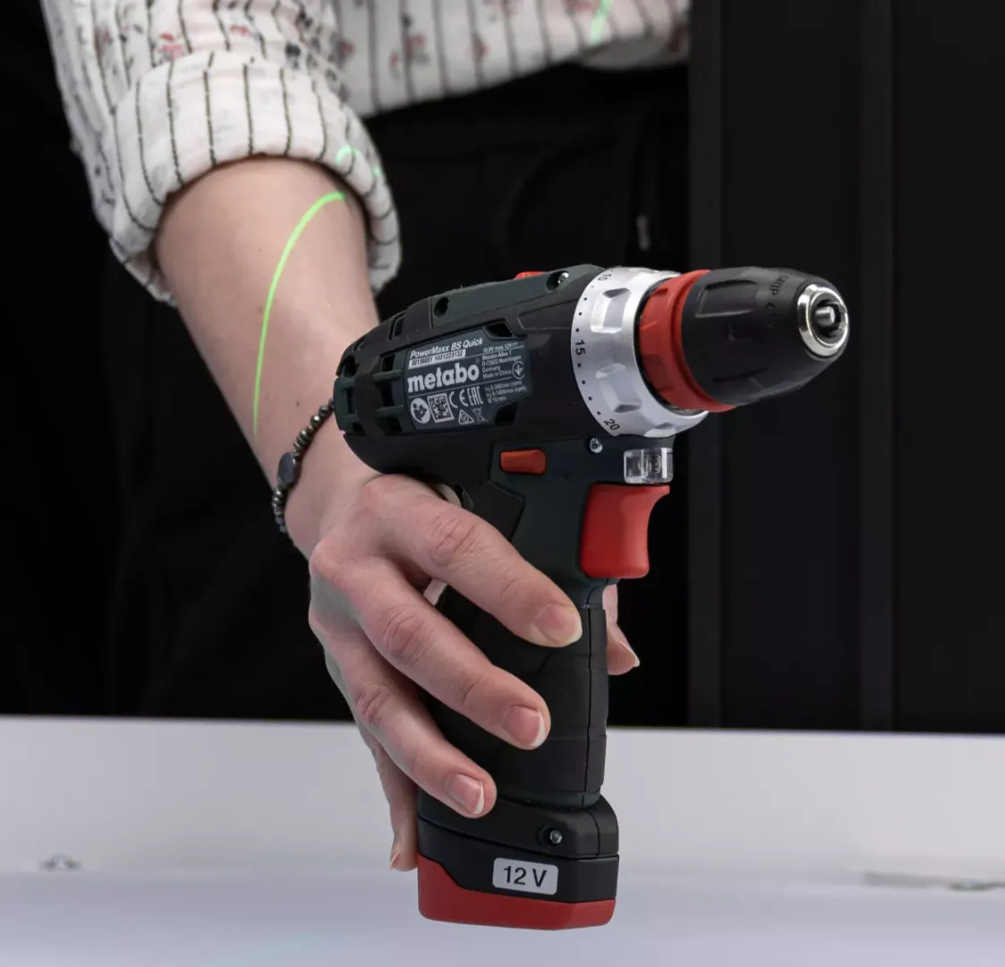 Gros plan de la perceuse Metabo tenue à la main