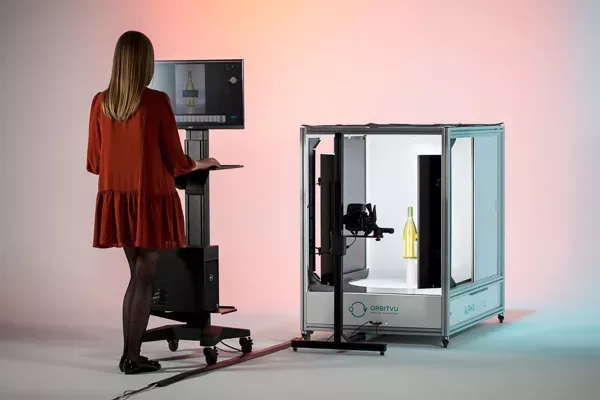 Femme utilisant une cabine automatisée de photographie de produits