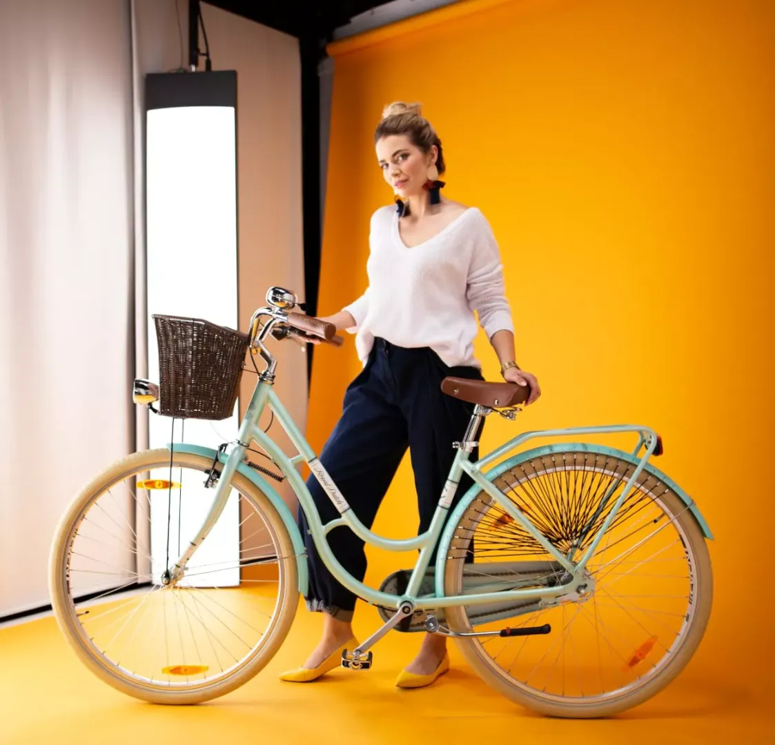 Modèle debout à côté d’un vélo dans le studio de photographie avec modèle vivant Orbitvu