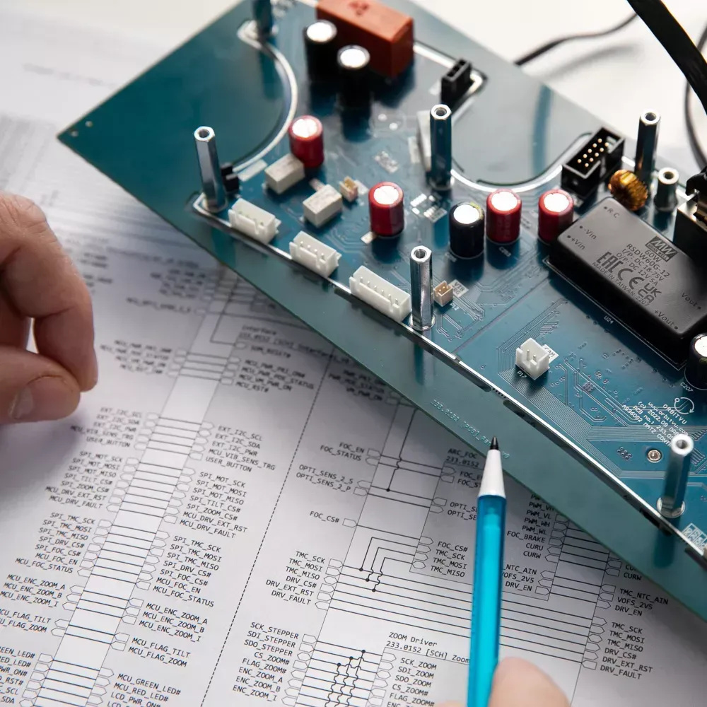 Ingénieur examinant une carte de circuit imprimé électronique et un schéma
