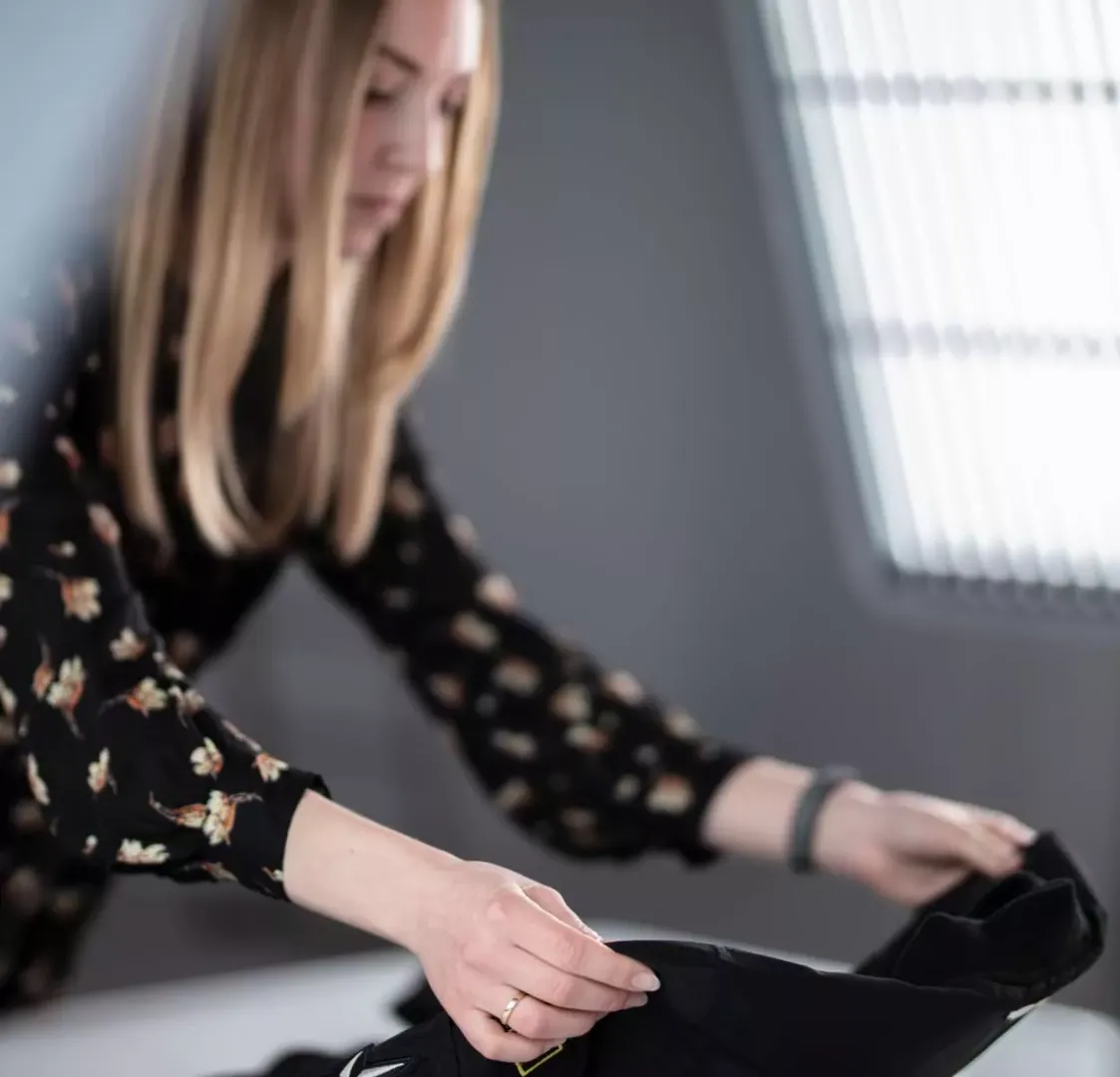 Styliste produit disposant un vêtement noir pour une séance flat lay