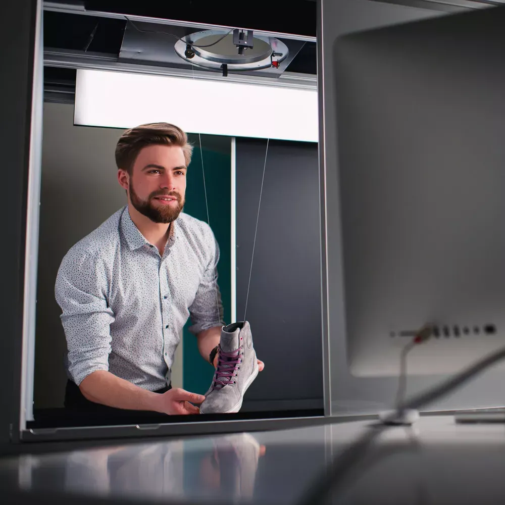 Homme préparant un produit pour une photographie professionnelle de chaussures