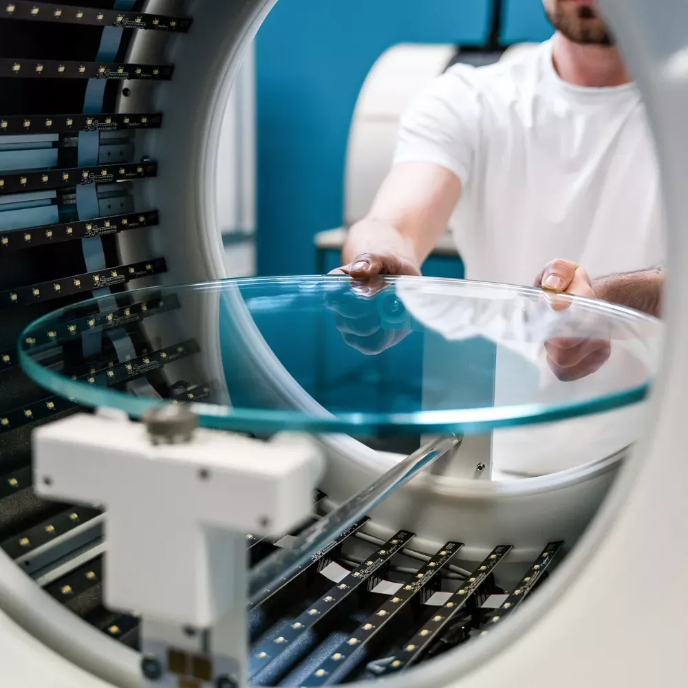 Technicien plaçant un plateau tournant en verre dans un studio photo automatisé
